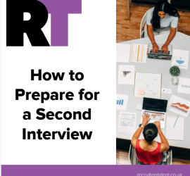 Three interviewers across a table from a candidate in a bright office